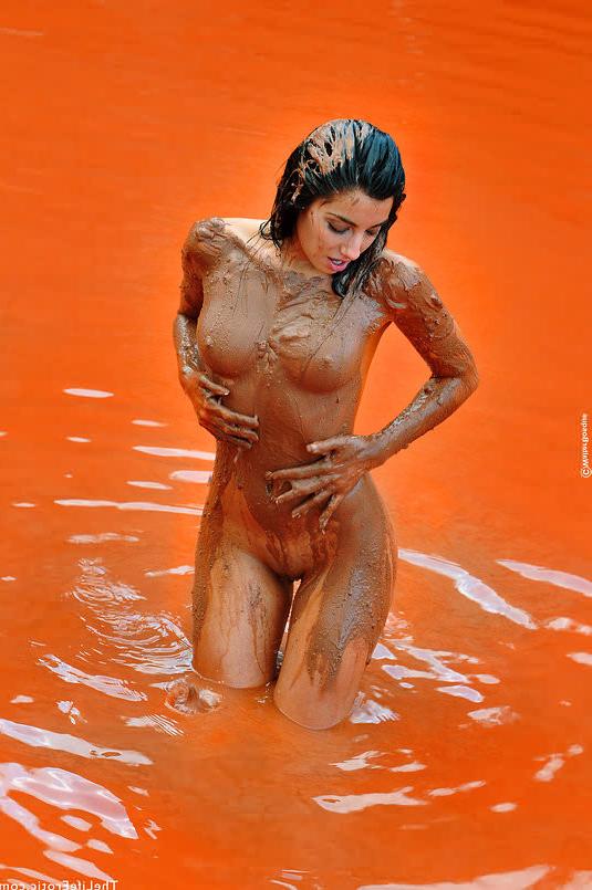 16P Nude beauty smearing her body in red mud outdoors in rocky pool