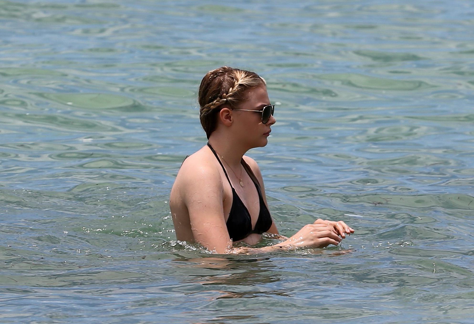 16P Chloe Moretz shows off her juicy ass in a skimpy black bikini at the beach in Mi