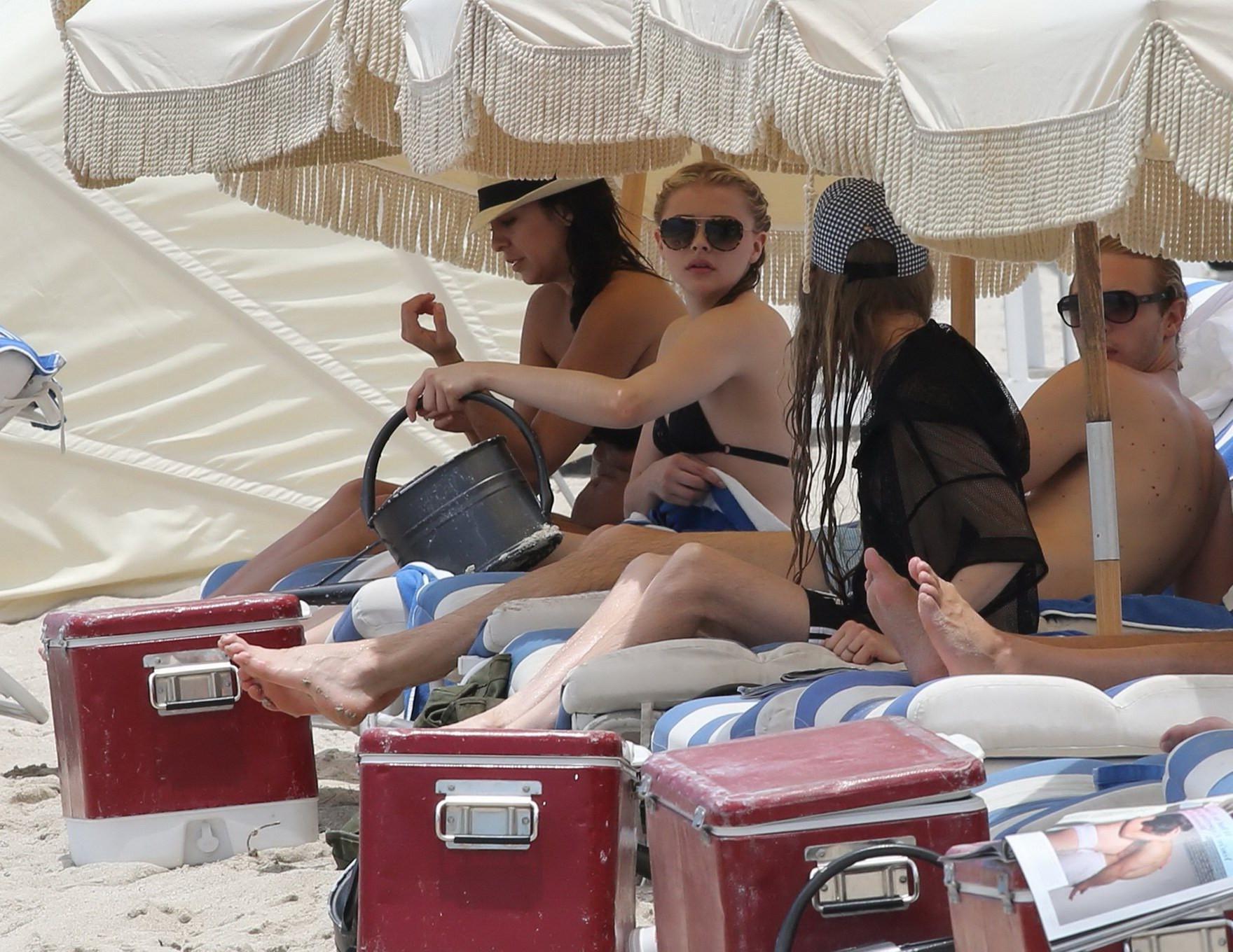 16P Chloe Moretz shows off her juicy ass in a skimpy black bikini at the beach in Mi
