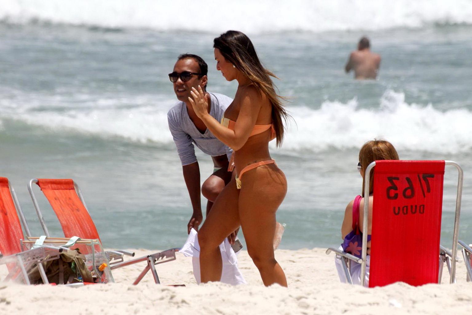 10P Nicole Bahls showing off her boobs  ass while tanning topless on a beach in Rio
