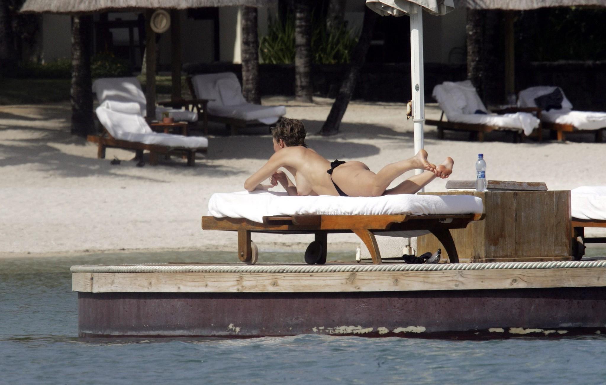 16P Karen Mulder tanning topless on a beach in Mauritius