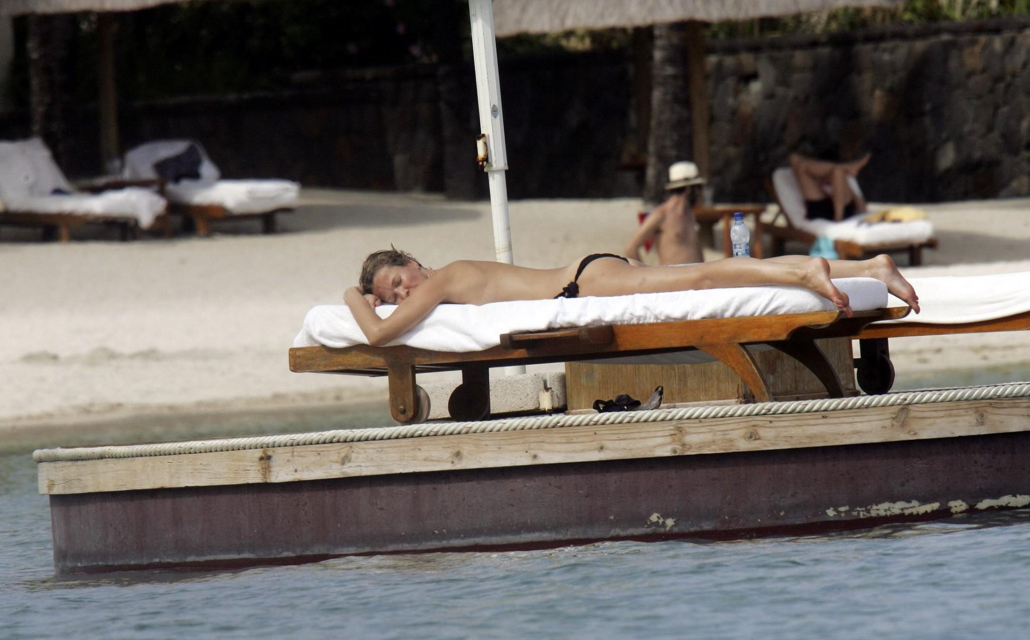 16P Karen Mulder tanning topless on a beach in Mauritius