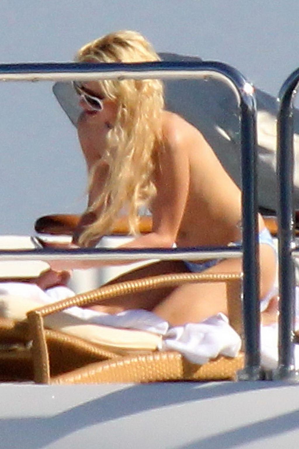 15P Paris Hilton topless showing off her small tits on a yacht in Italy