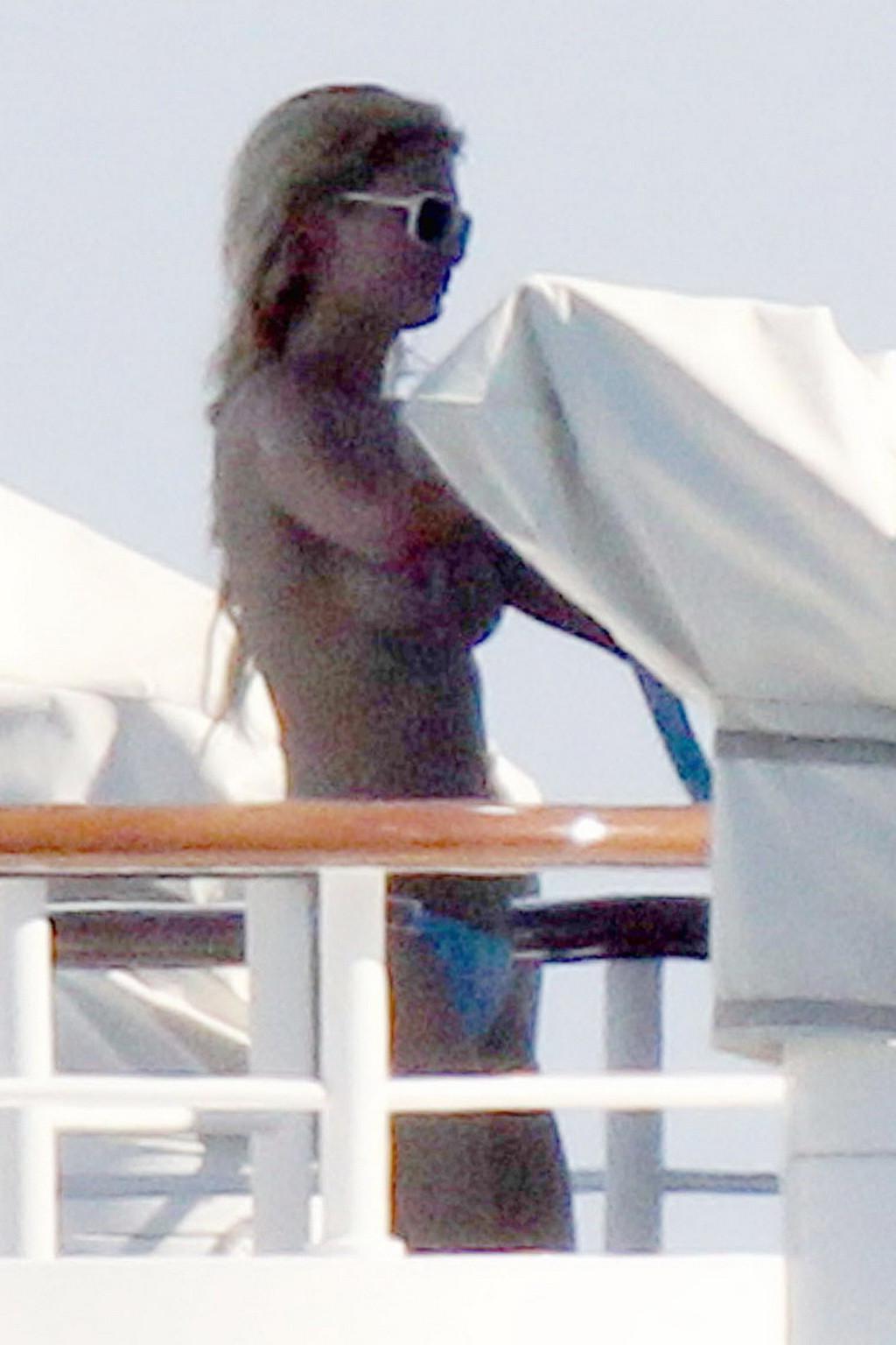 15P Paris Hilton topless showing off her small tits on a yacht in Italy