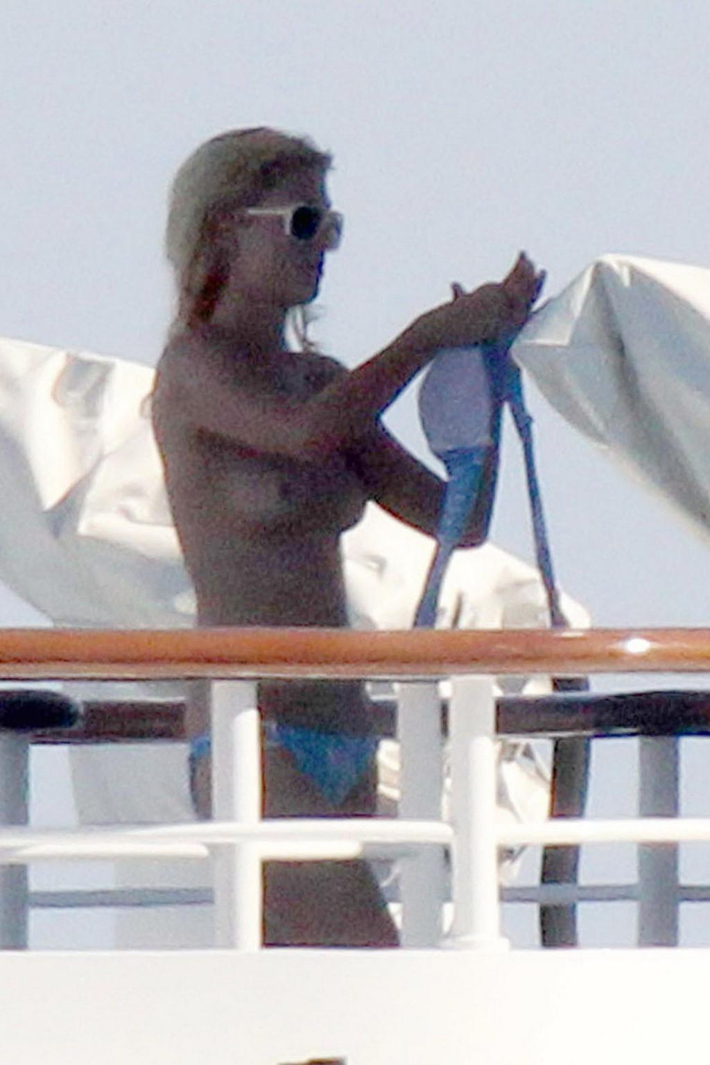 15P Paris Hilton topless showing off her small tits on a yacht in Italy