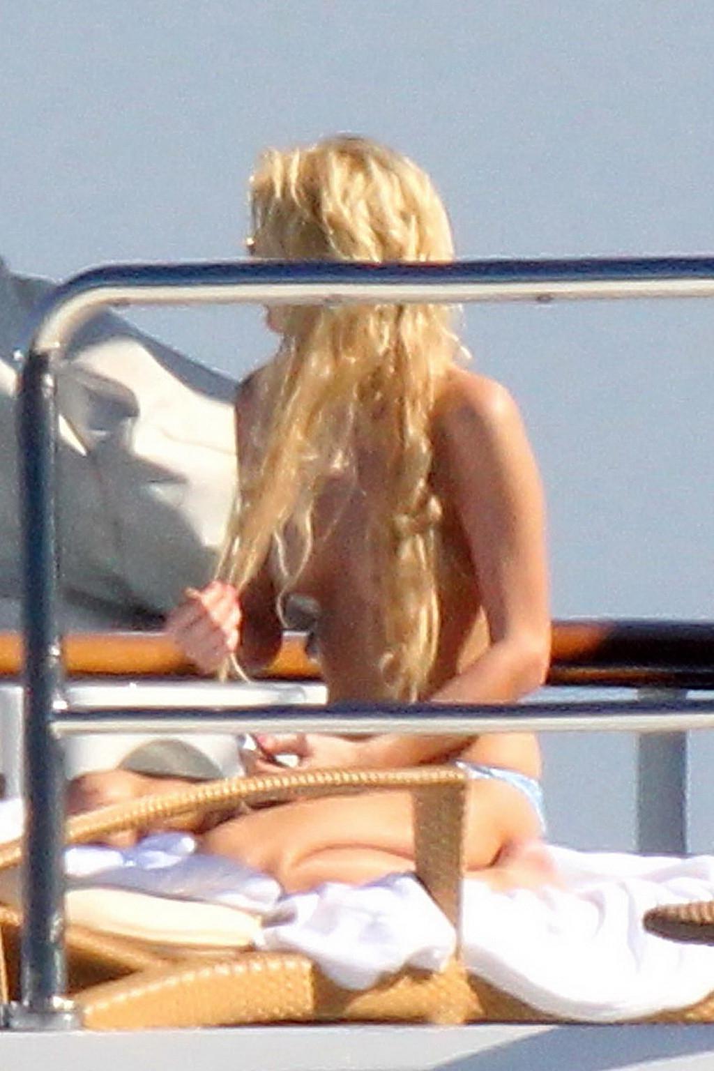 15P Paris Hilton topless showing off her small tits on a yacht in Italy
