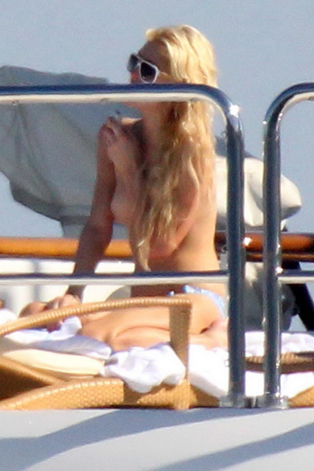 15P Paris Hilton topless showing off her small tits on a yacht in Italy