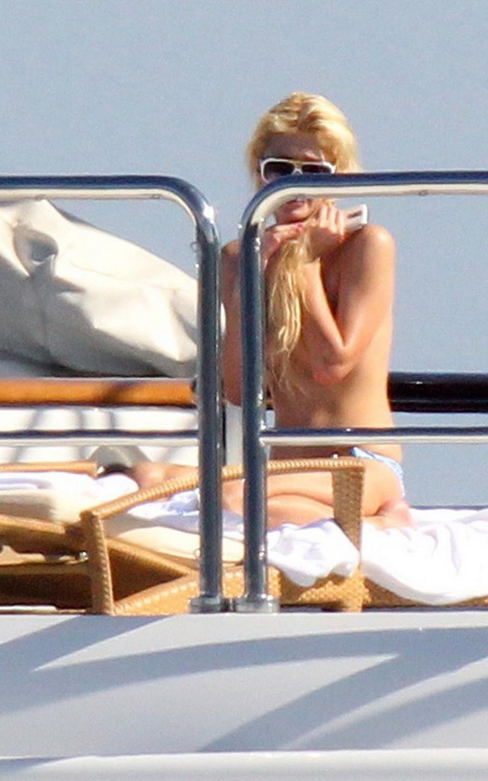 15P Paris Hilton topless showing off her small tits on a yacht in Italy