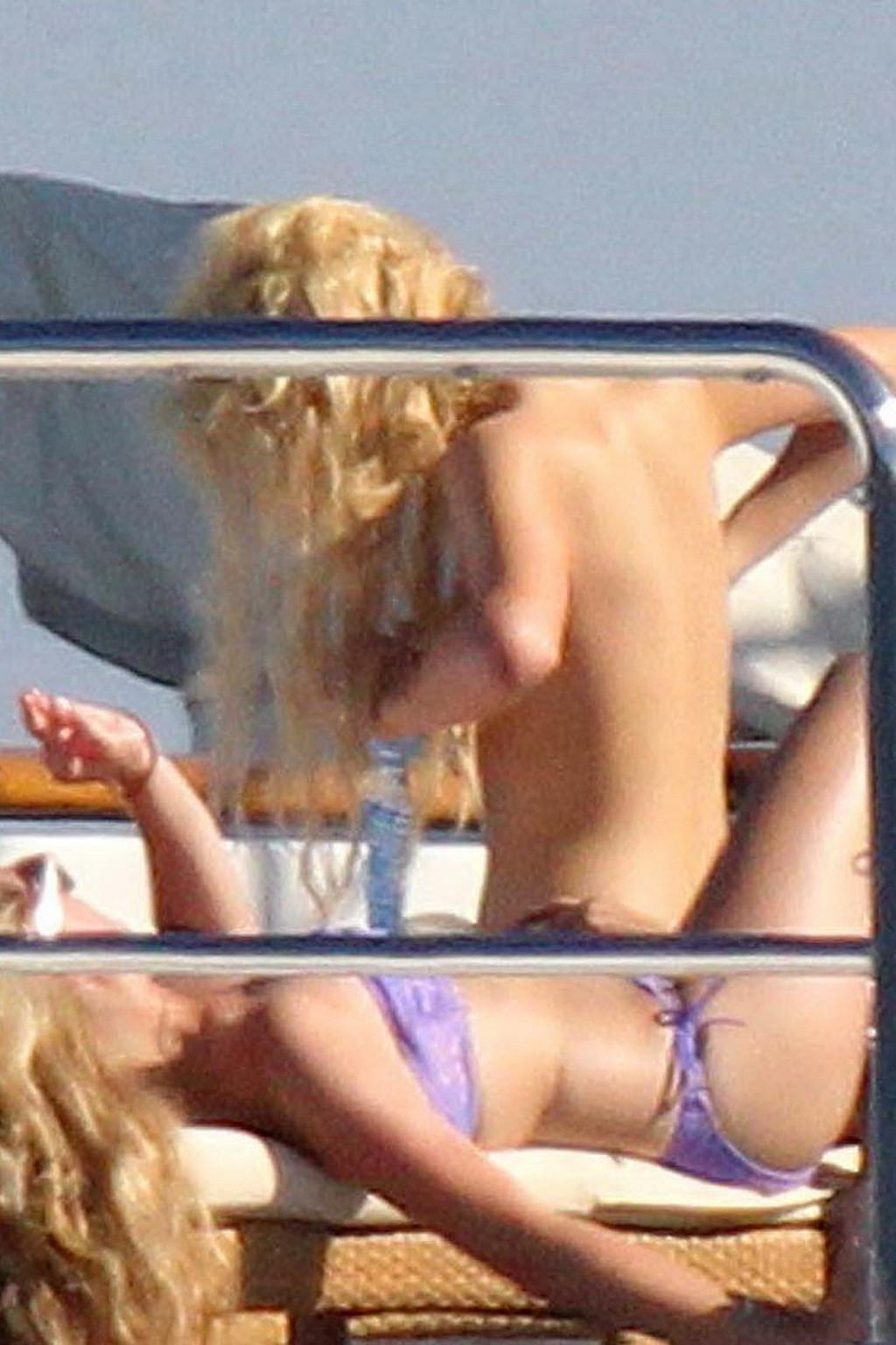 15P Paris Hilton topless showing off her small tits on a yacht in Italy