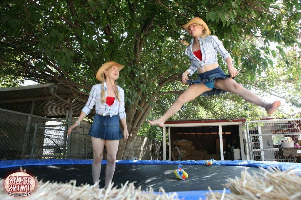 15P Twin teen sisters play with water pistols and jump on trampoline