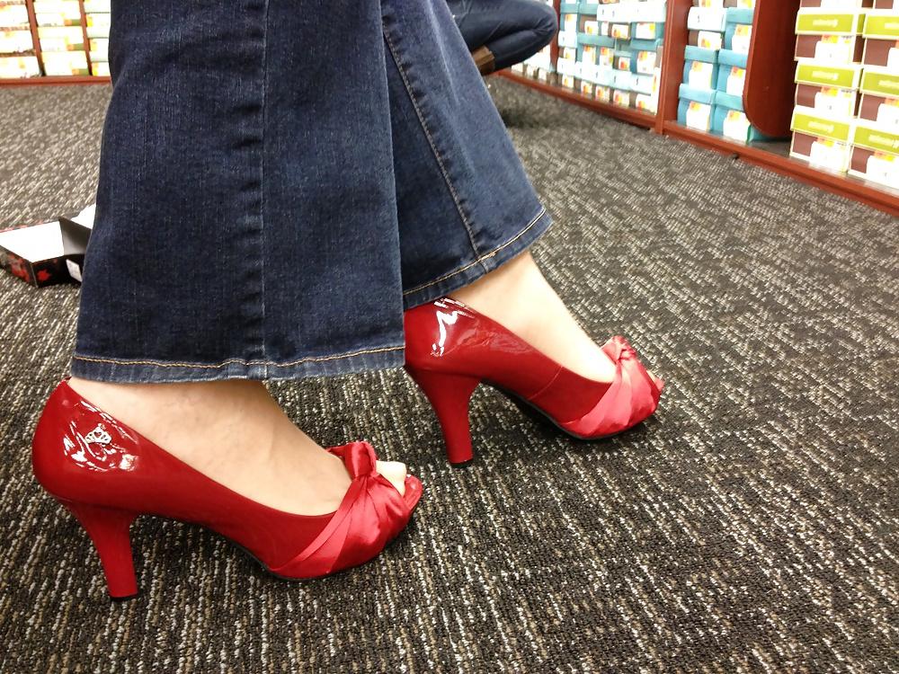 13P Stocking feet trying on red heels in shoe store