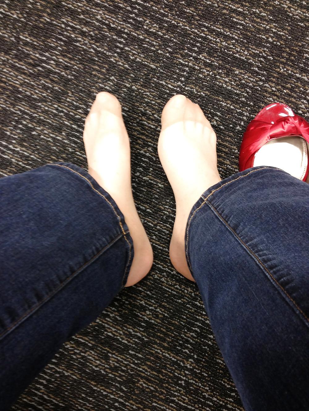 13P Stocking feet trying on red heels in shoe store