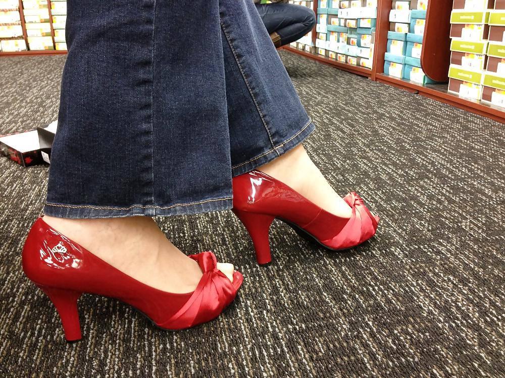 13P Stocking feet trying on red heels in shoe store
