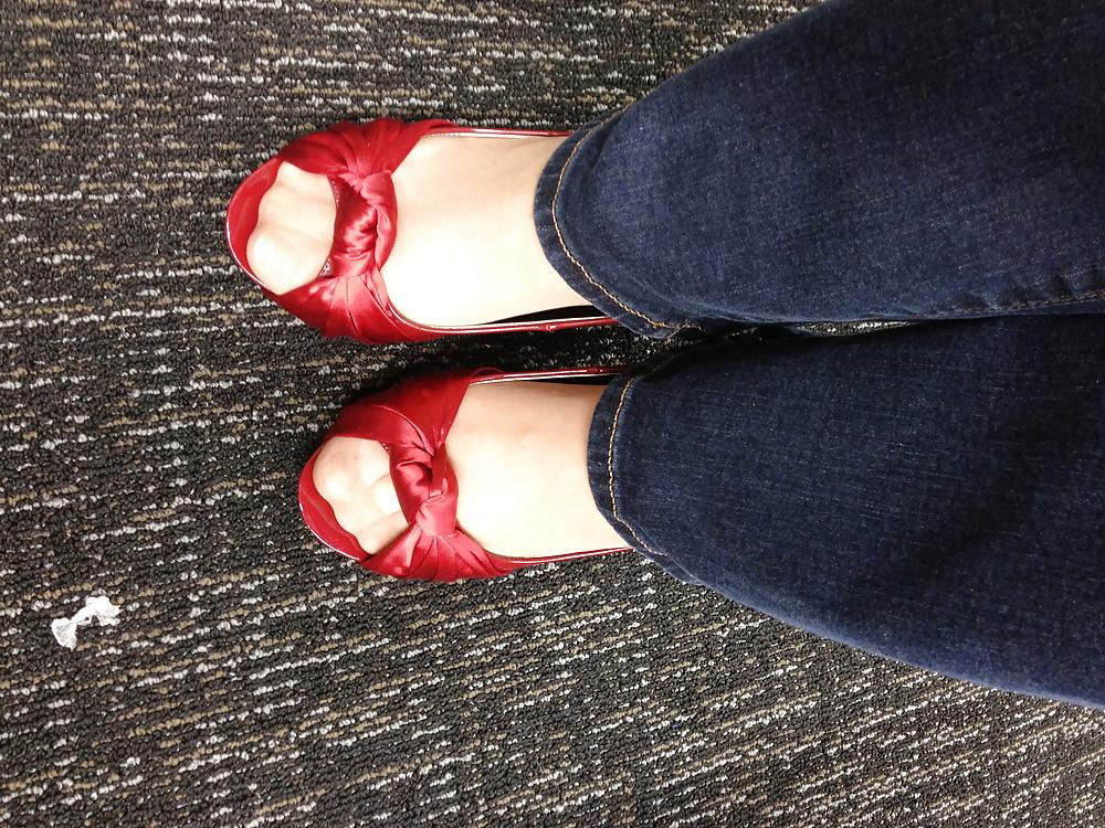13P Stocking feet trying on red heels in shoe store