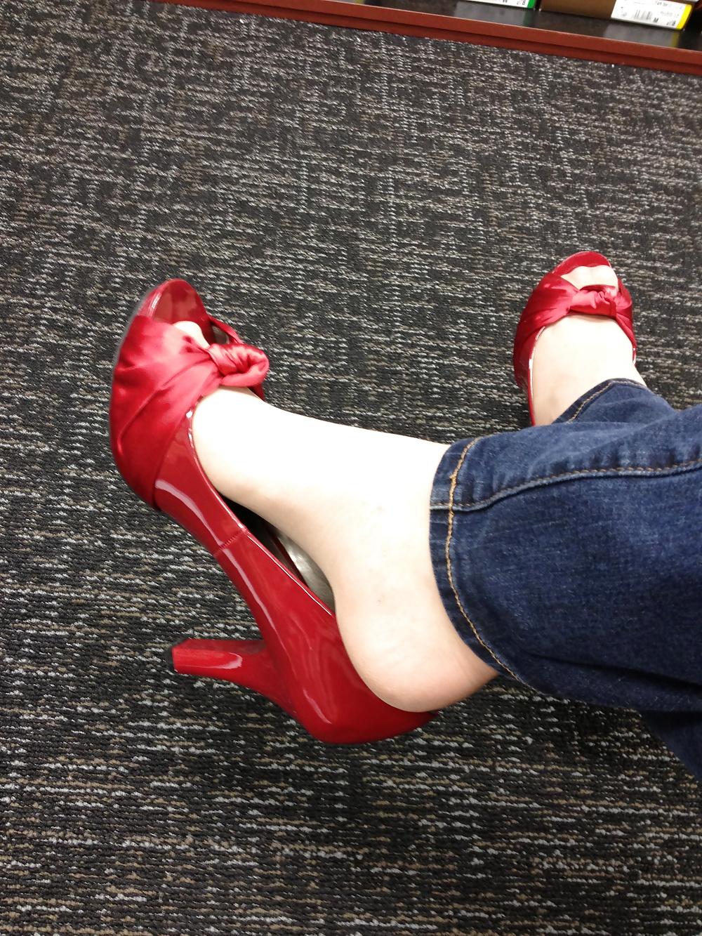 13P Stocking feet trying on red heels in shoe store