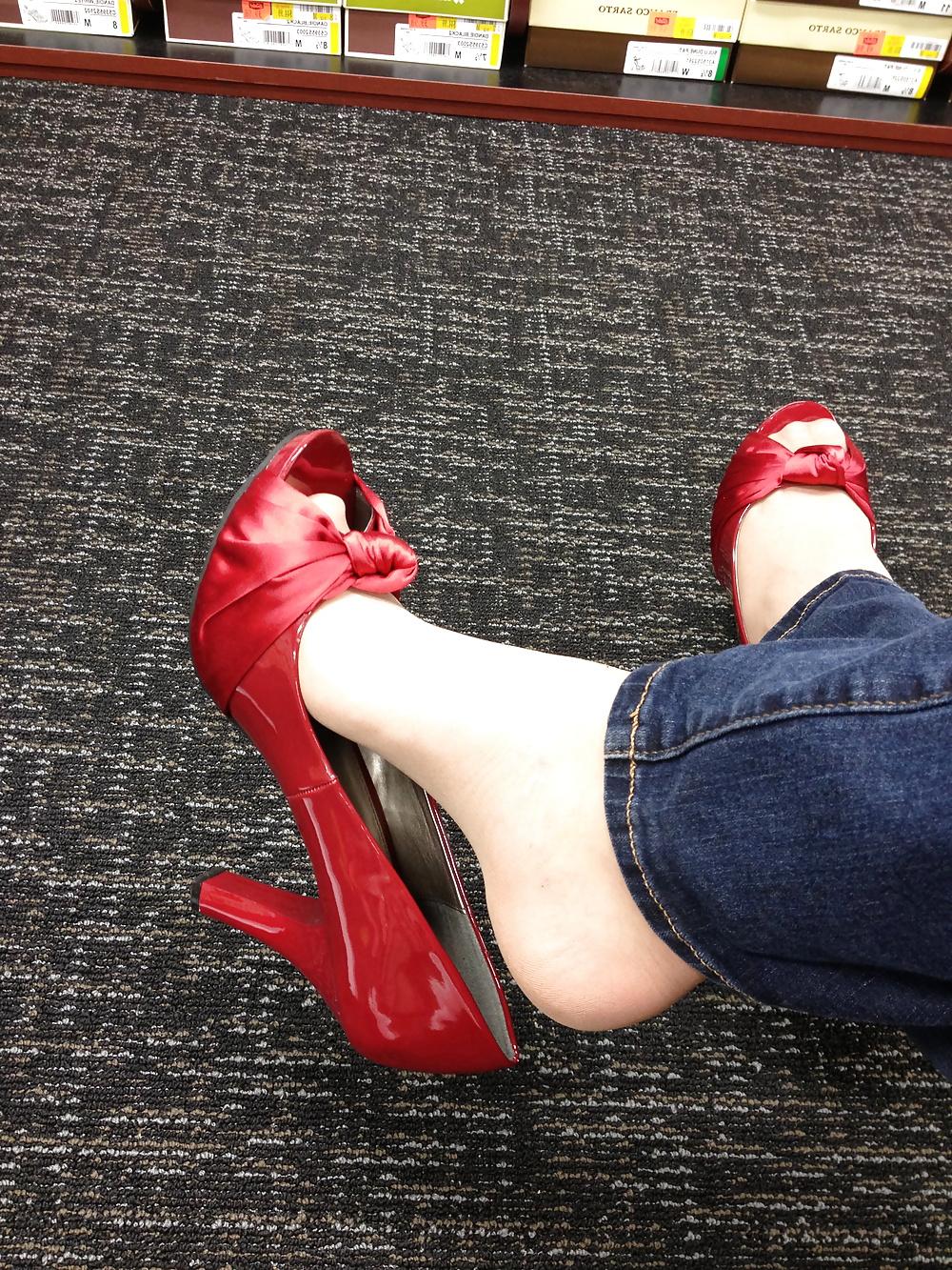 13P Stocking feet trying on red heels in shoe store