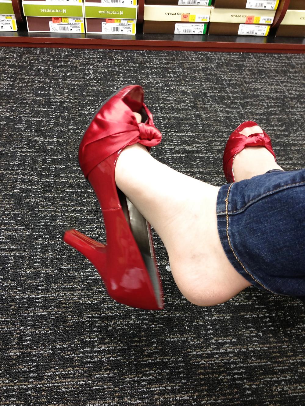 13P Stocking feet trying on red heels in shoe store