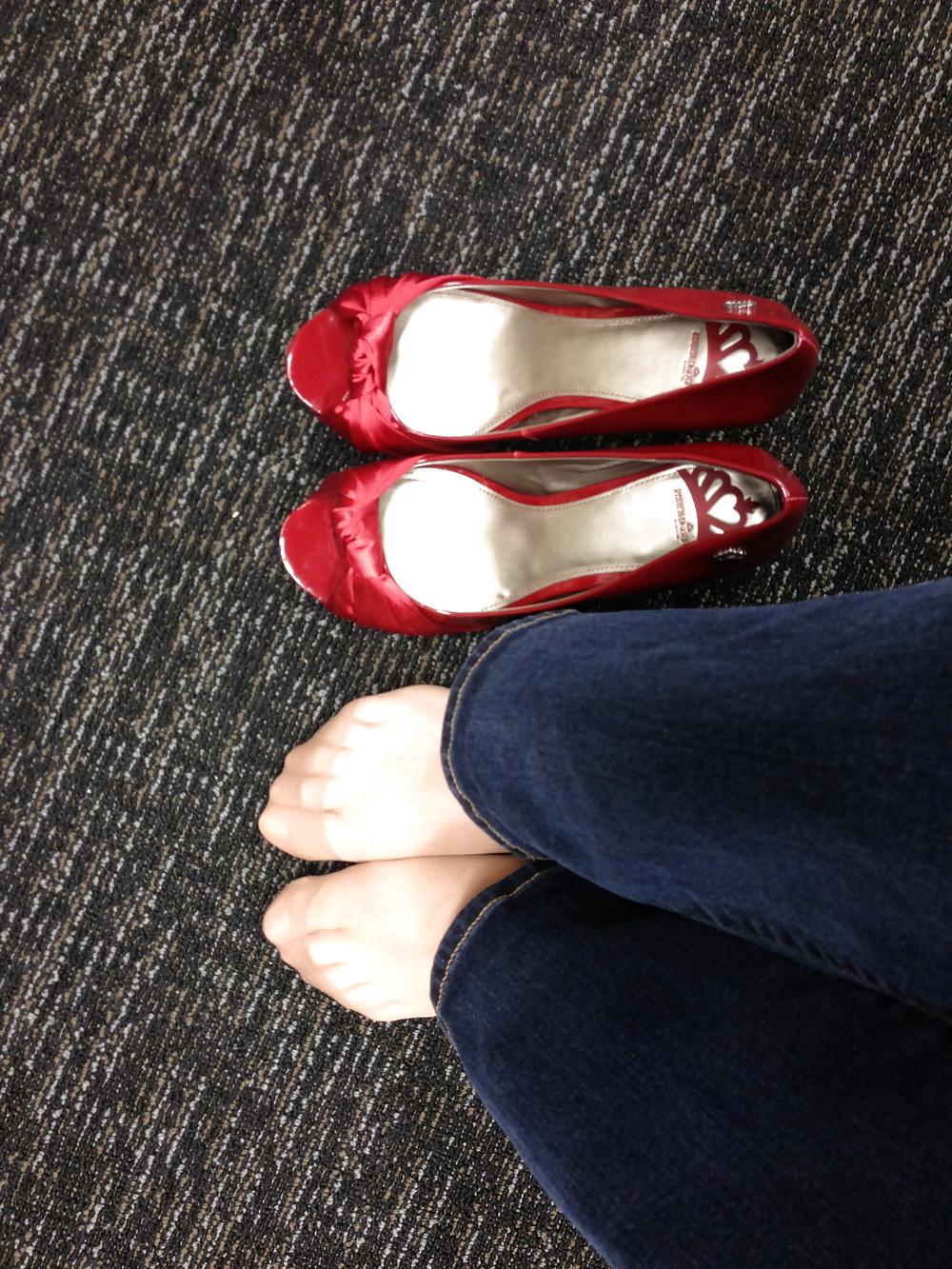 13P Stocking feet trying on red heels in shoe store