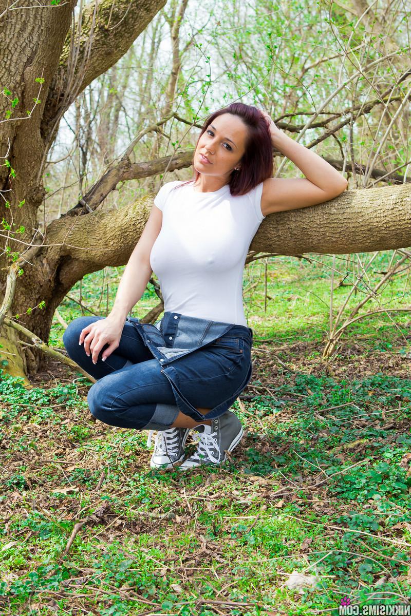 15P Stunning redhead babe Nikki removes her tight shirt in the woods