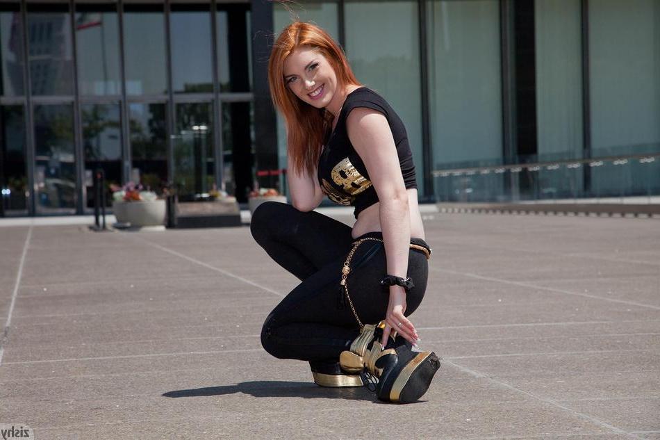 8P Redhead babe Lilith Lust flashes her crotch tatoo outside