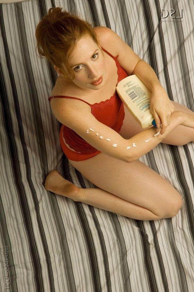 16P Pictures of a hot redhead teen rubbing lotion on her hot nude body