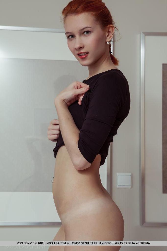 18P Redhead teen Ambre gets naked by the window in "Amenthi"