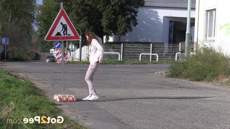 15P Brunette girl makes a pissy puddle on the road