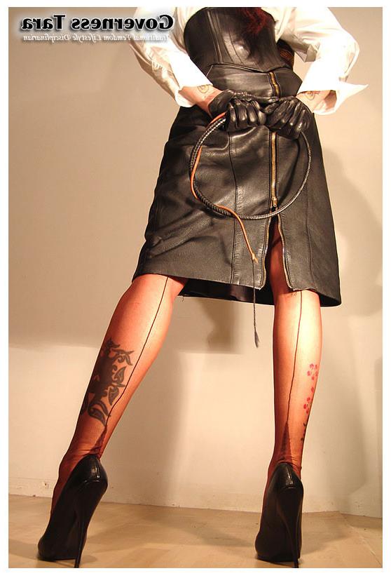 15P A strict brunette mistress posing in leather and high heels