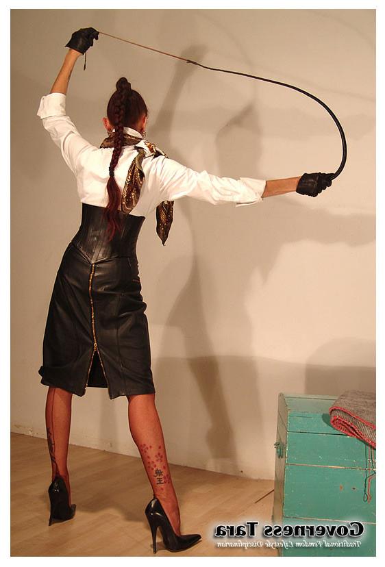 15P A strict brunette mistress posing in leather and high heels