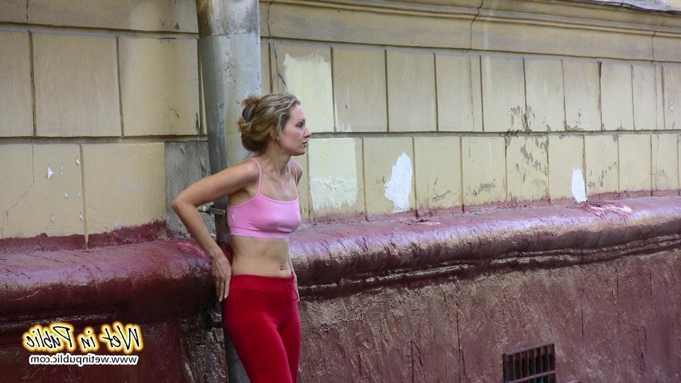 16P Cutie hides behind a truck to pee right through her red sporty pants
