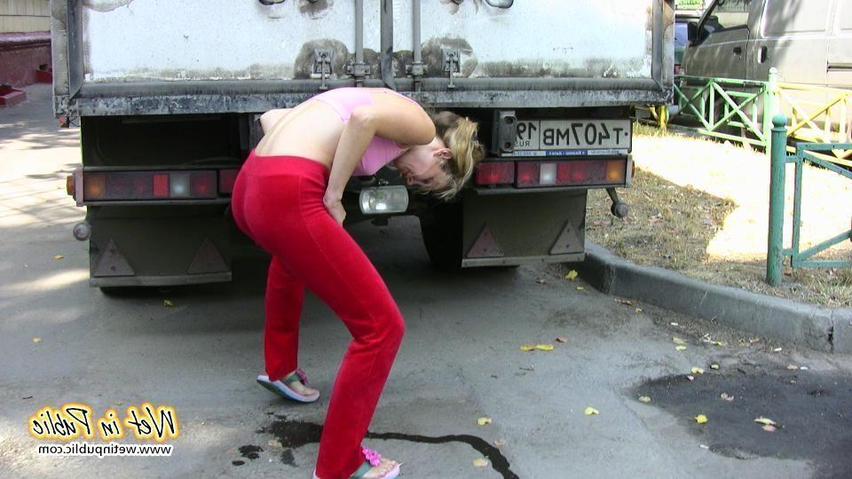 16P Cutie hides behind a truck to pee right through her red sporty pants