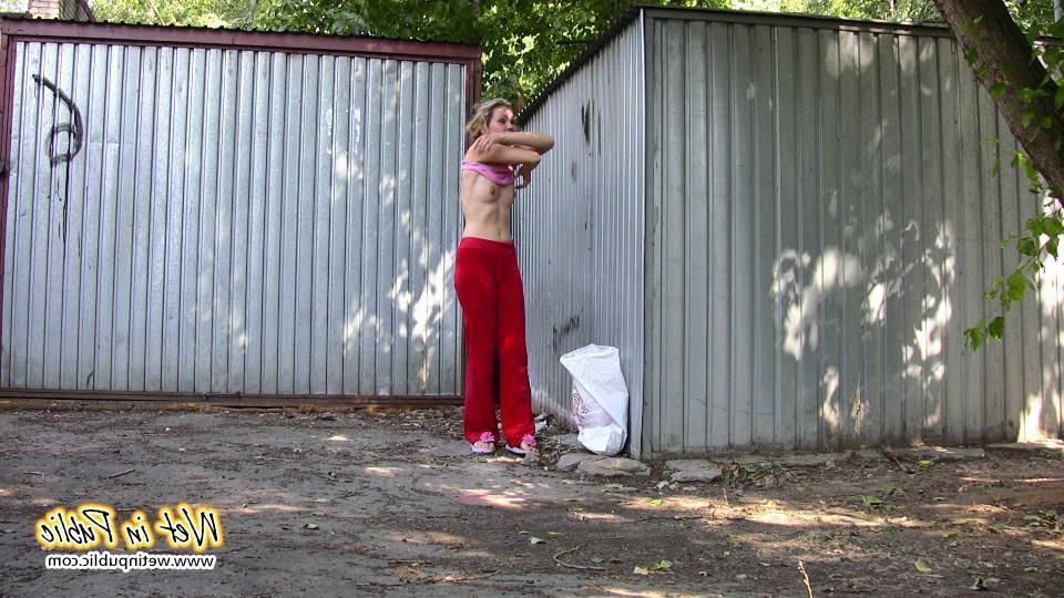 16P Cutie hides behind a truck to pee right through her red sporty pants