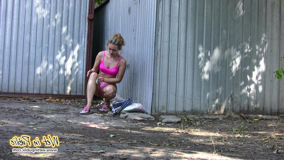 16P Cutie hides behind a truck to pee right through her red sporty pants