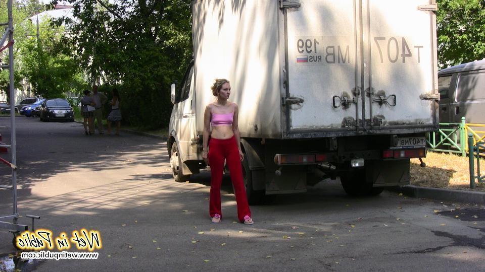 16P Cutie hides behind a truck to pee right through her red sporty pants