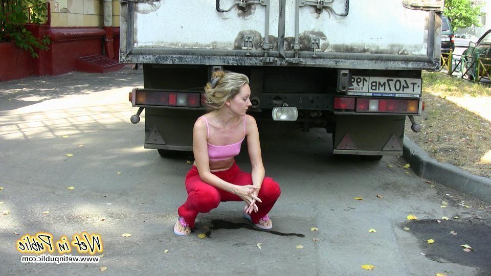 16P Cutie hides behind a truck to pee right through her red sporty pants