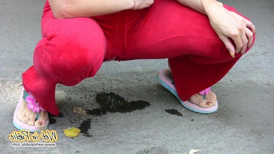 16P Cutie hides behind a truck to pee right through her red sporty pants