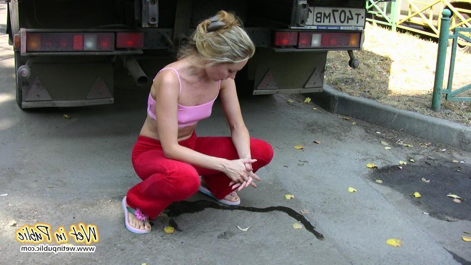 16P Cutie hides behind a truck to pee right through her red sporty pants