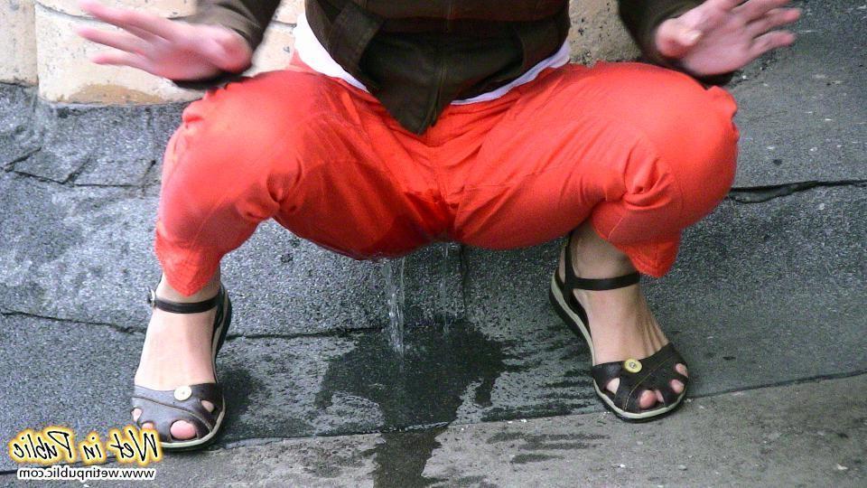 11P A pee stream splashing from a pussy in the red pants right in public