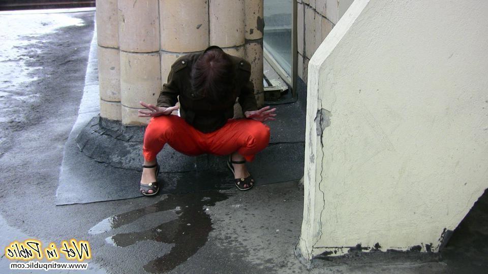 11P A pee stream splashing from a pussy in the red pants right in public