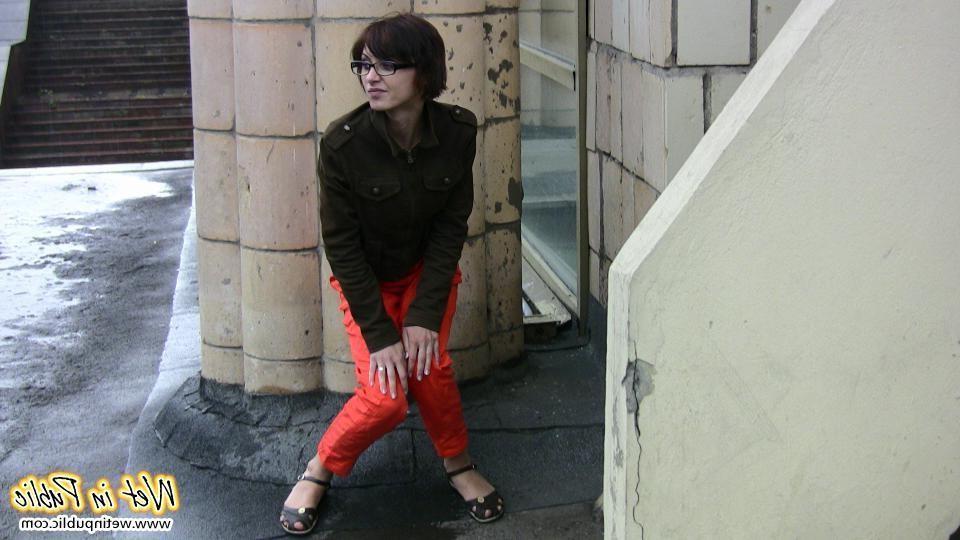 11P A pee stream splashing from a pussy in the red pants right in public