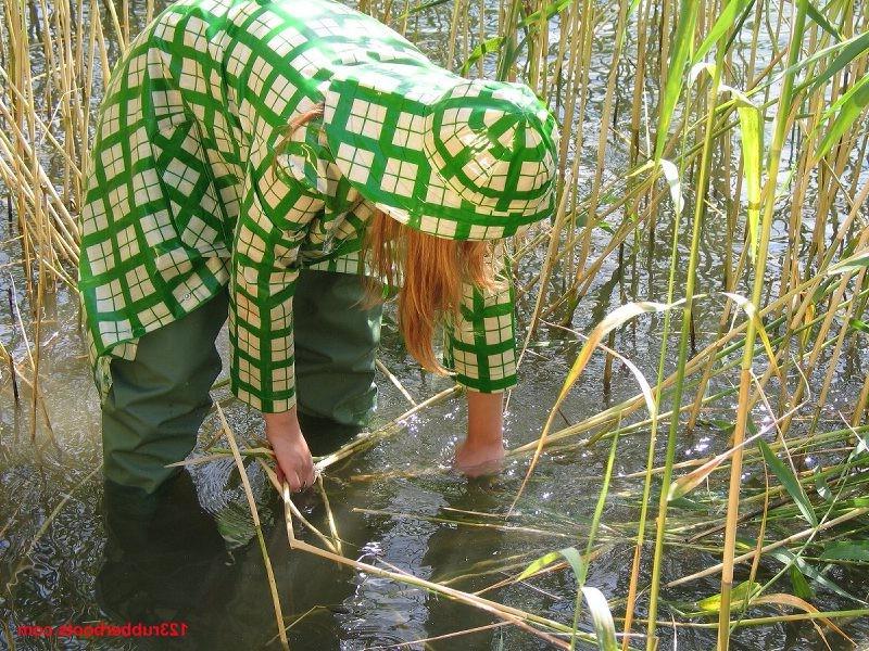 20P Girl in green rainwear and fishermans rubber boots