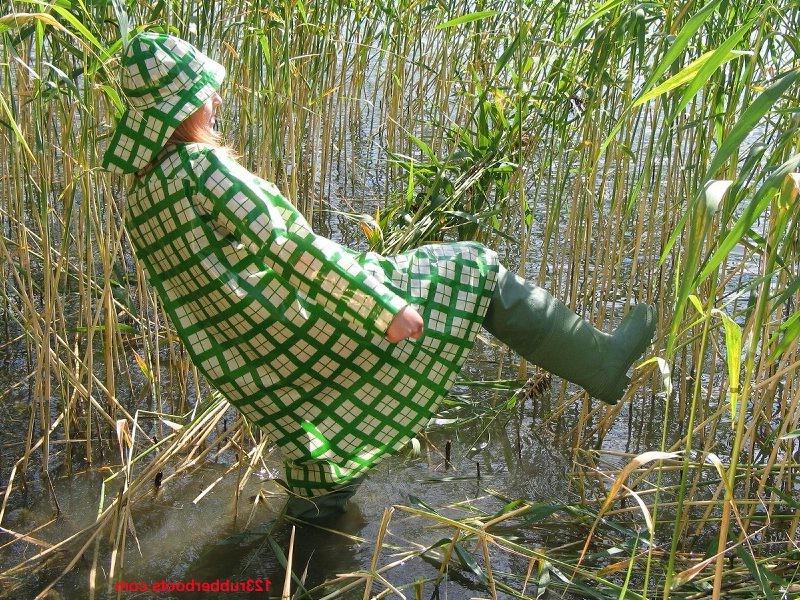 20P Girl in green rainwear and fishermans rubber boots