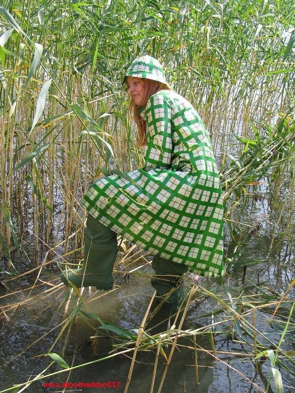 20P Girl in green rainwear and fishermans rubber boots