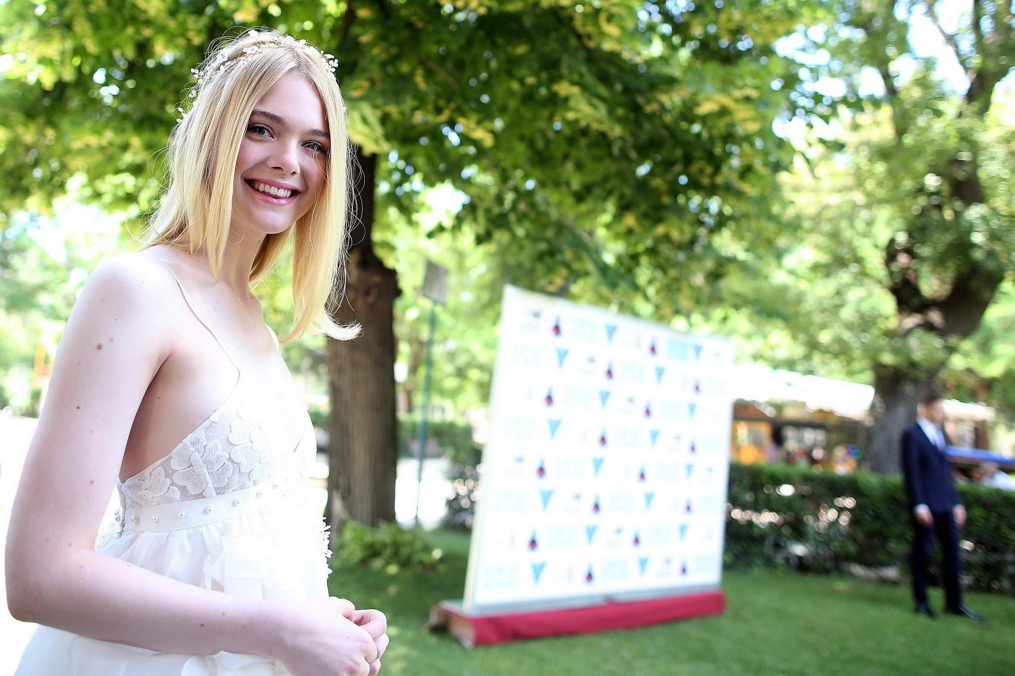 15P Elle Fanning cleavy and leggy in white lace dress