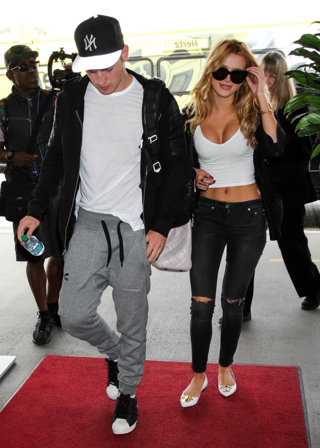16P Bella Thorne shows huge cleavage wearing white crop top at LAX