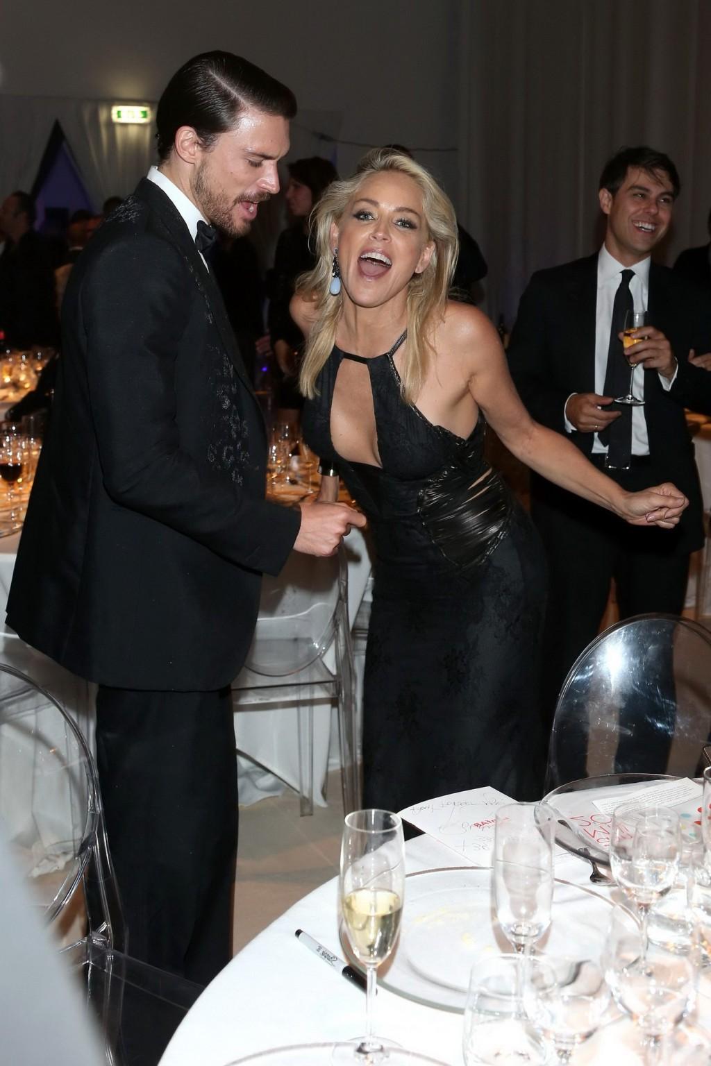 10P Sharon Stone showing cleavage at amfAR event during Milan Fashion Week