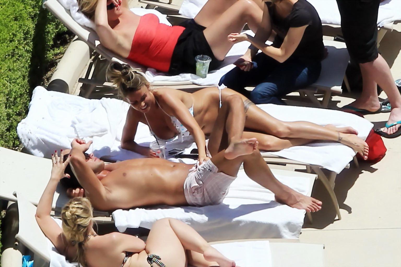 10P Busty babe Katie Price jerking a cock over shorts in public at the pool in Las V