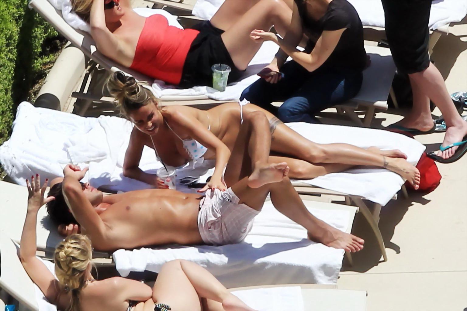 10P Busty babe Katie Price jerking a cock over shorts in public at the pool in Las V