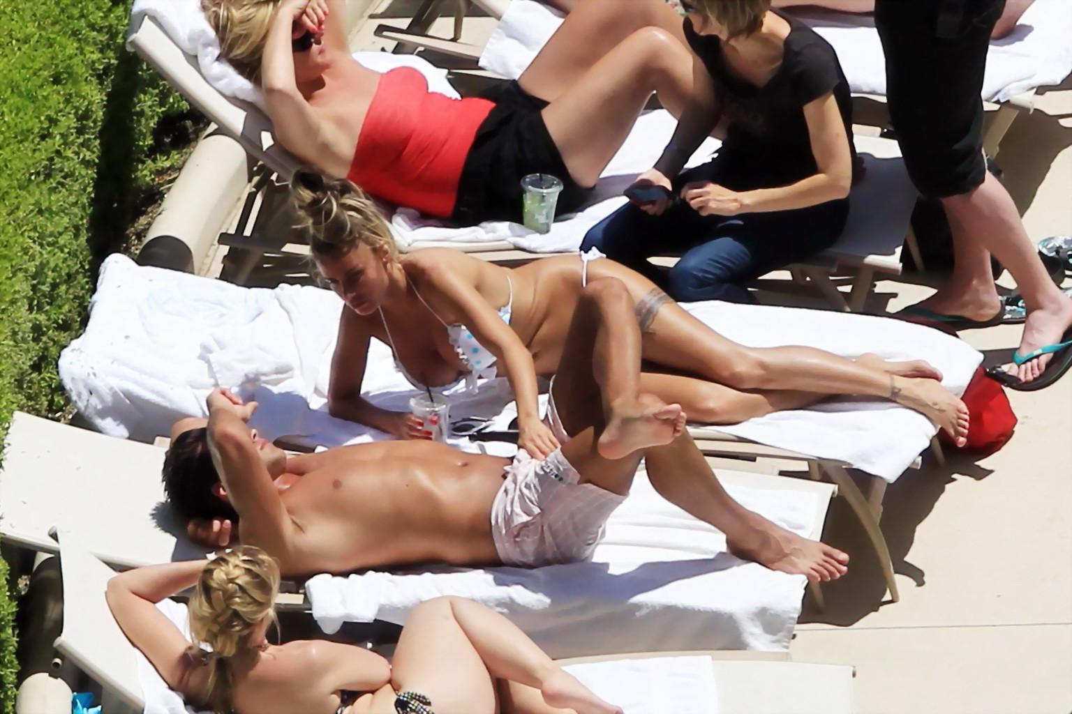 10P Busty babe Katie Price jerking a cock over shorts in public at the pool in Las V