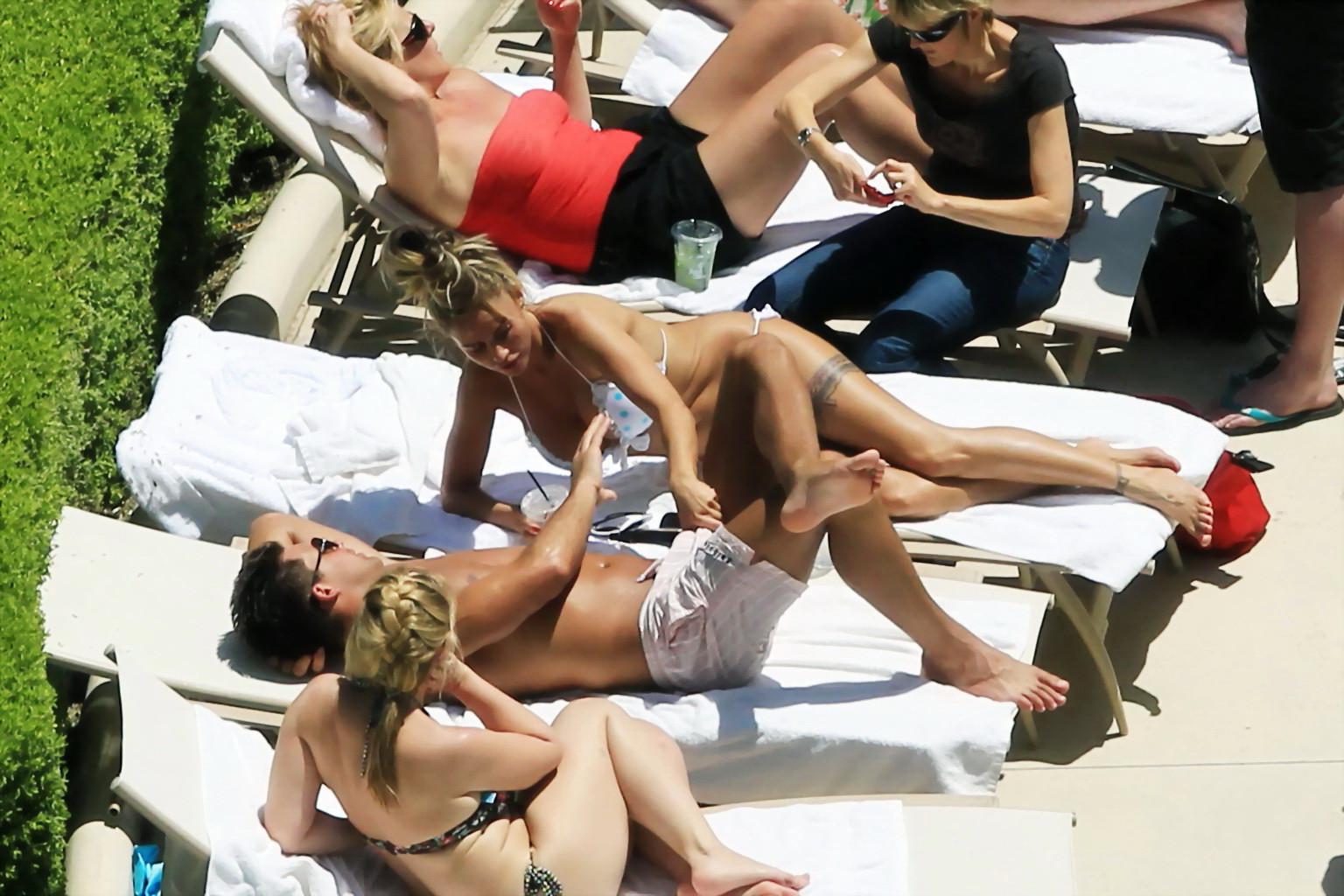 10P Busty babe Katie Price jerking a cock over shorts in public at the pool in Las V